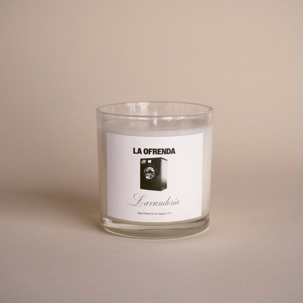Candle with a label reading 'La Ofrenda' on a beige background