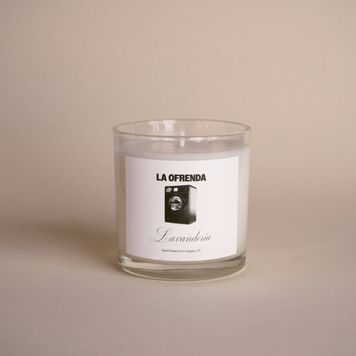 Candle with a label reading 'La Ofrenda' on a beige background